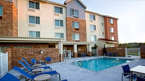 A hotel with a swimming pool, lounge chairs, and a patio area. - TownePlace Suites by Marriott Little Rock West (Little Rock)
