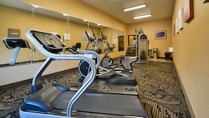 A gym with treadmills, elliptical machines, and a stationary bike.