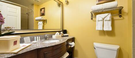 A bathroom with a sink, mirror, towel rack, and toilet.