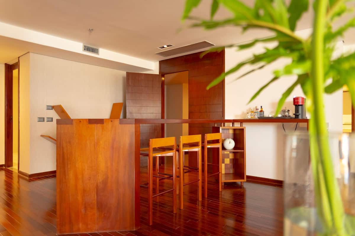 A modern kitchen with wooden cabinets, a built-in stove, and a coffee machine.