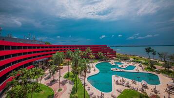 Surrounded by lush greenery and palm trees, this hotel offers a scenic view of the nearby water.