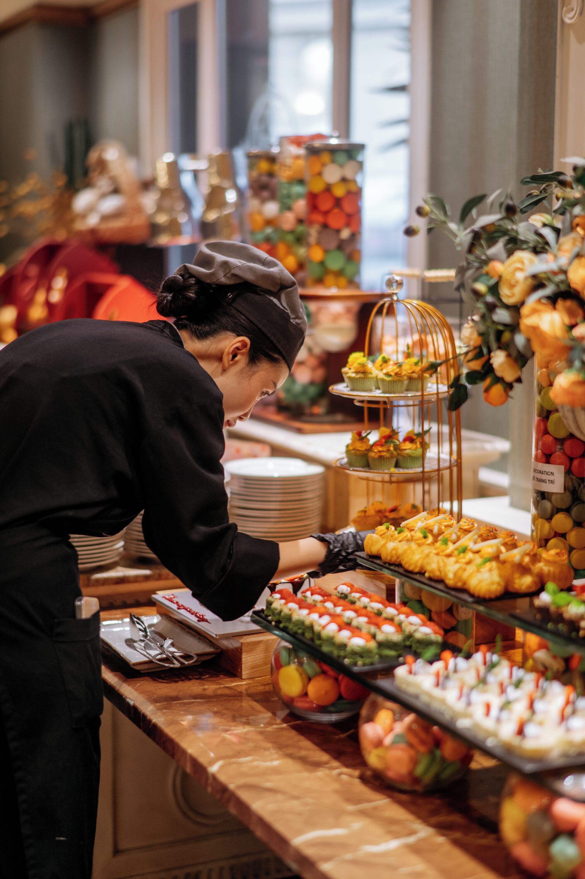 A buffet setup with various food items and a person serving.