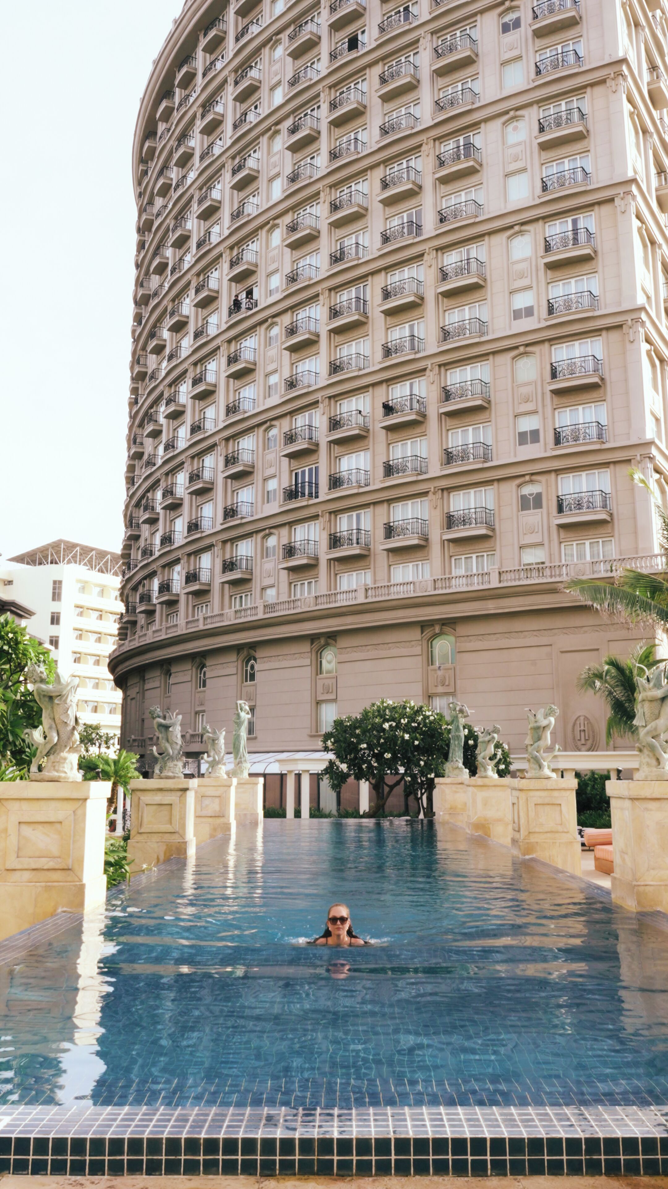 A large hotel with a swimming pool.