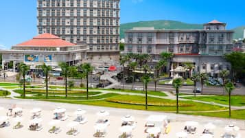 Pantai pribadi, pasir putih, kursi berjemur, dan payung pantai