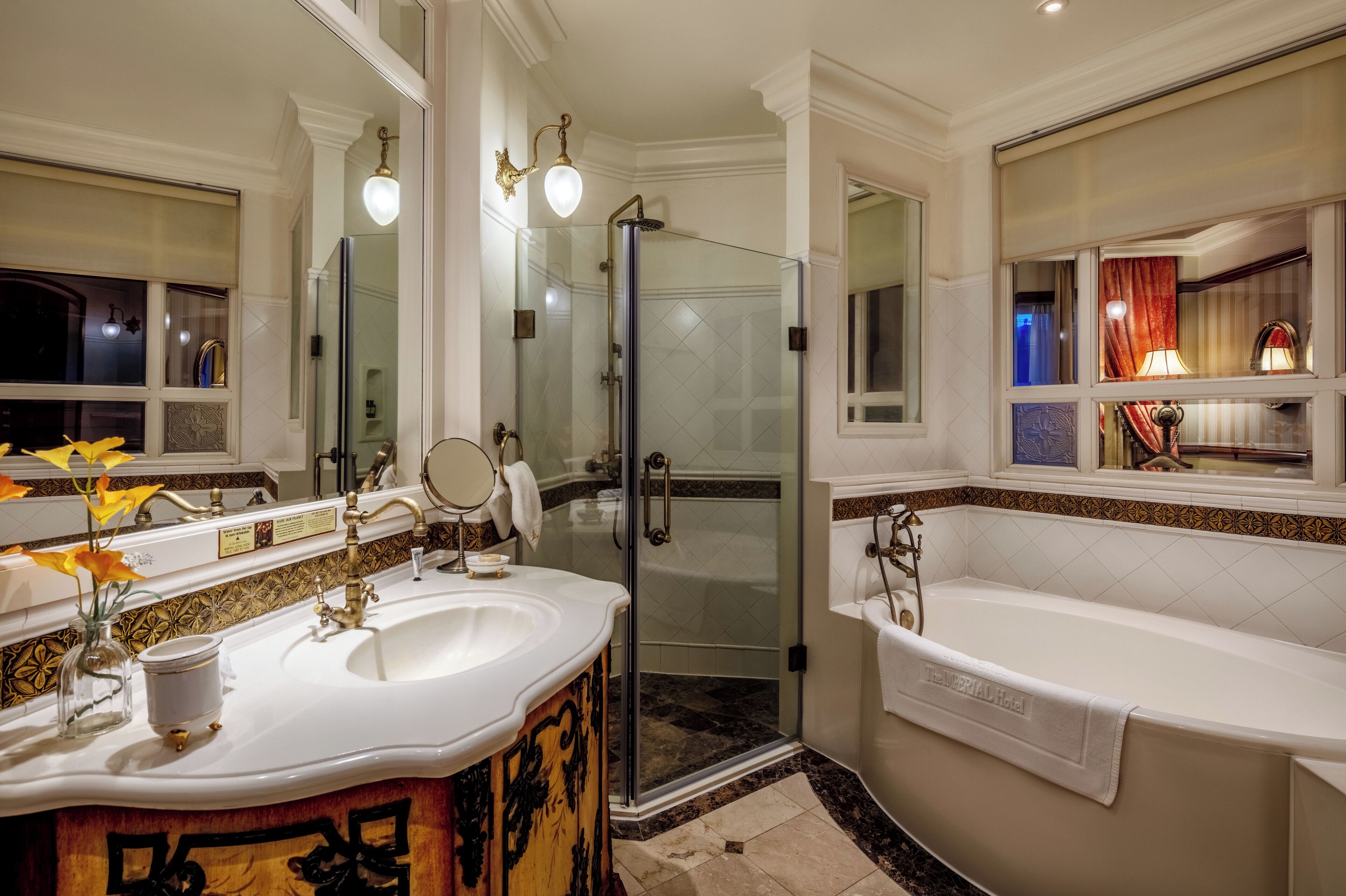 A luxurious bathroom with a large bathtub, a glass-enclosed shower, and a vanity with a mirror and sink.