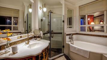 A luxurious bathroom with a large bathtub, a glass-enclosed shower, and a vanity with a mirror and sink.