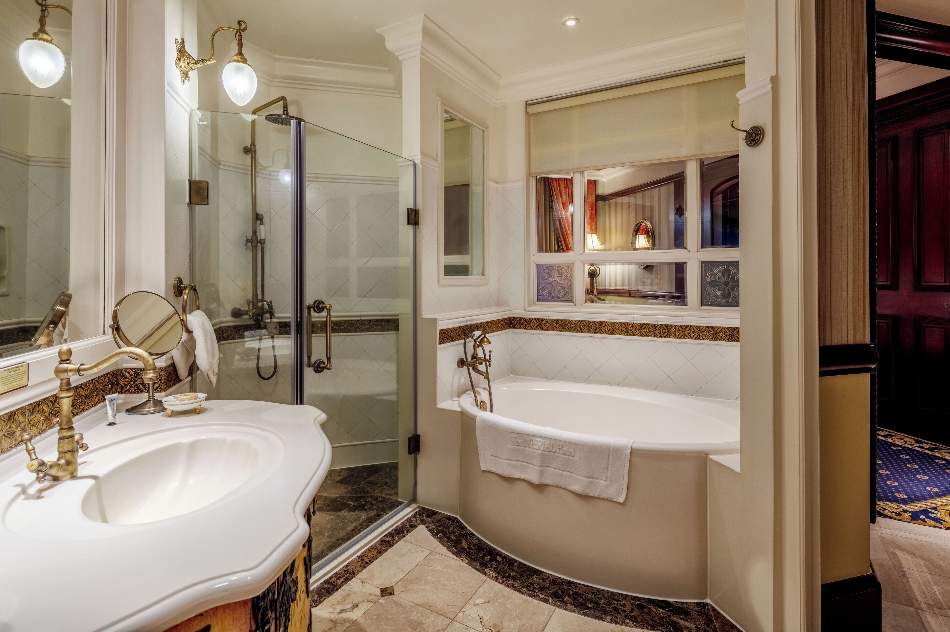 A bathroom with a double sink, a bathtub, and a glass-enclosed shower area.