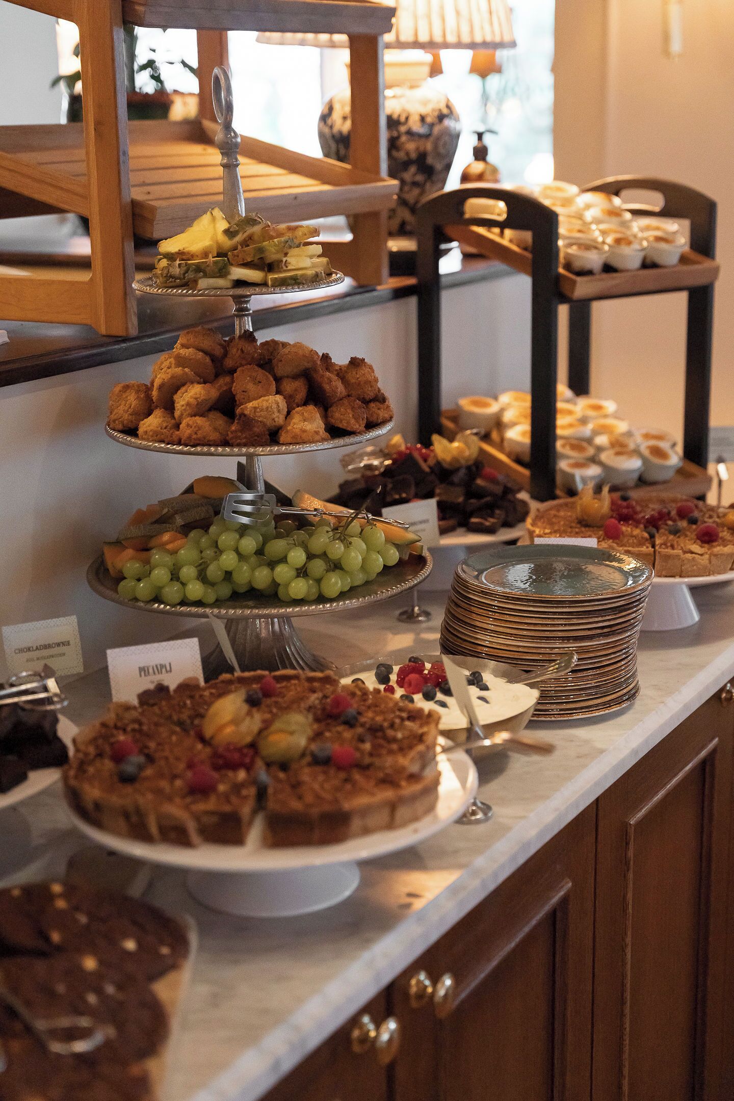 Ein reichhaltiges Buffet mit einer Auswahl an Speisen, darunter Kuchen, Gebäck und Früchten.