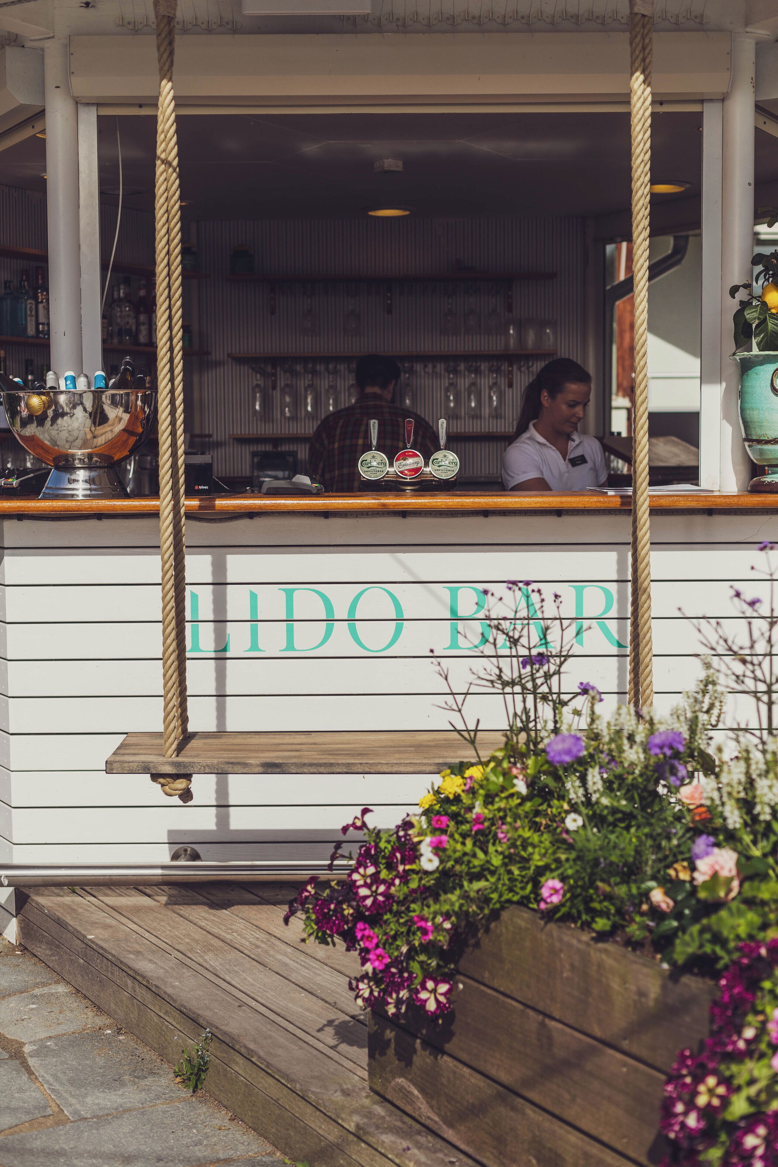 En bar som heter ”LIDO BAR” med en bardisk i trä och ett avspärrningsrep.
