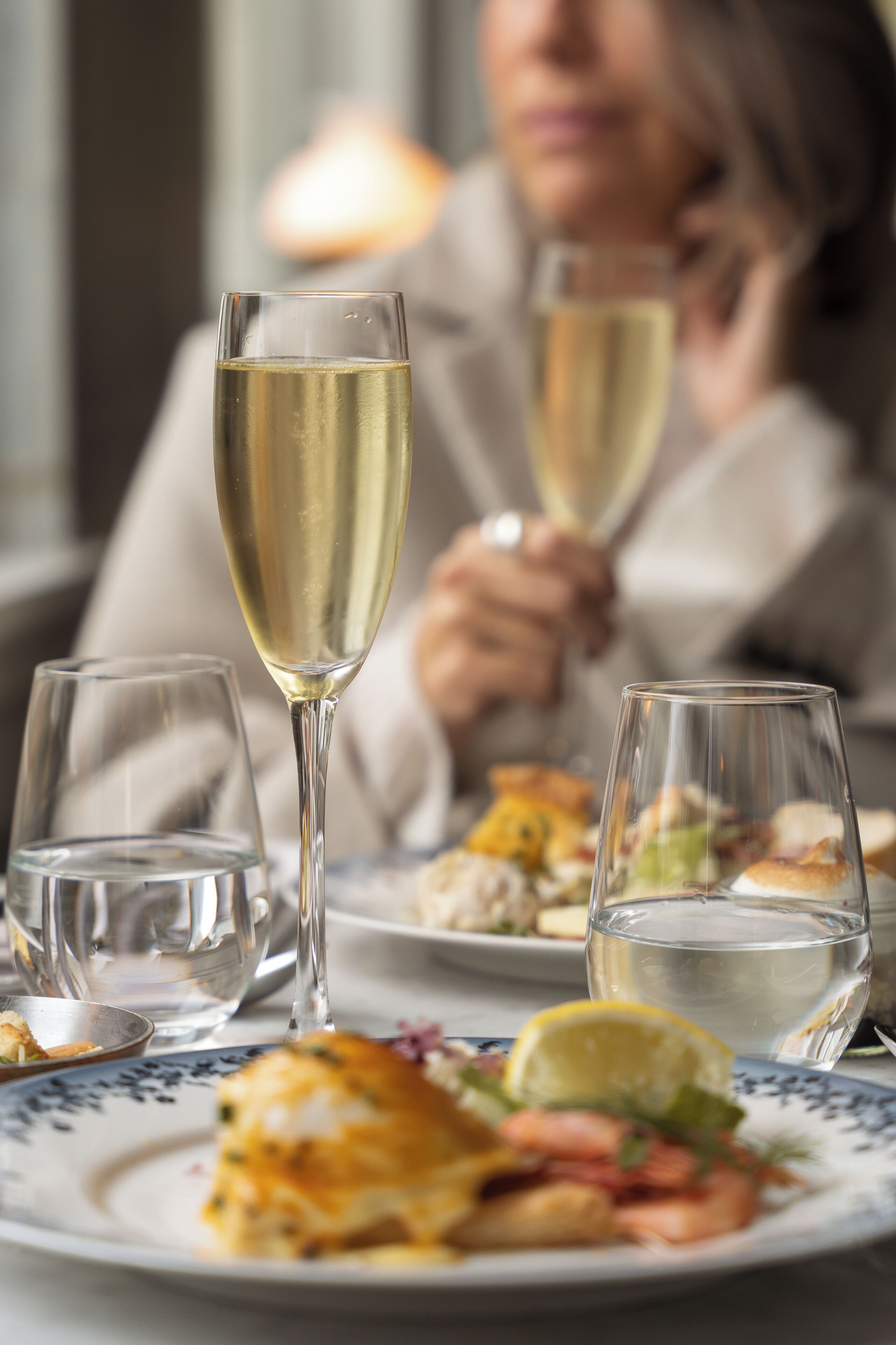 Ein Esstisch mit Speisen auf Tellern und Gläsern mit Wasser und Wein.