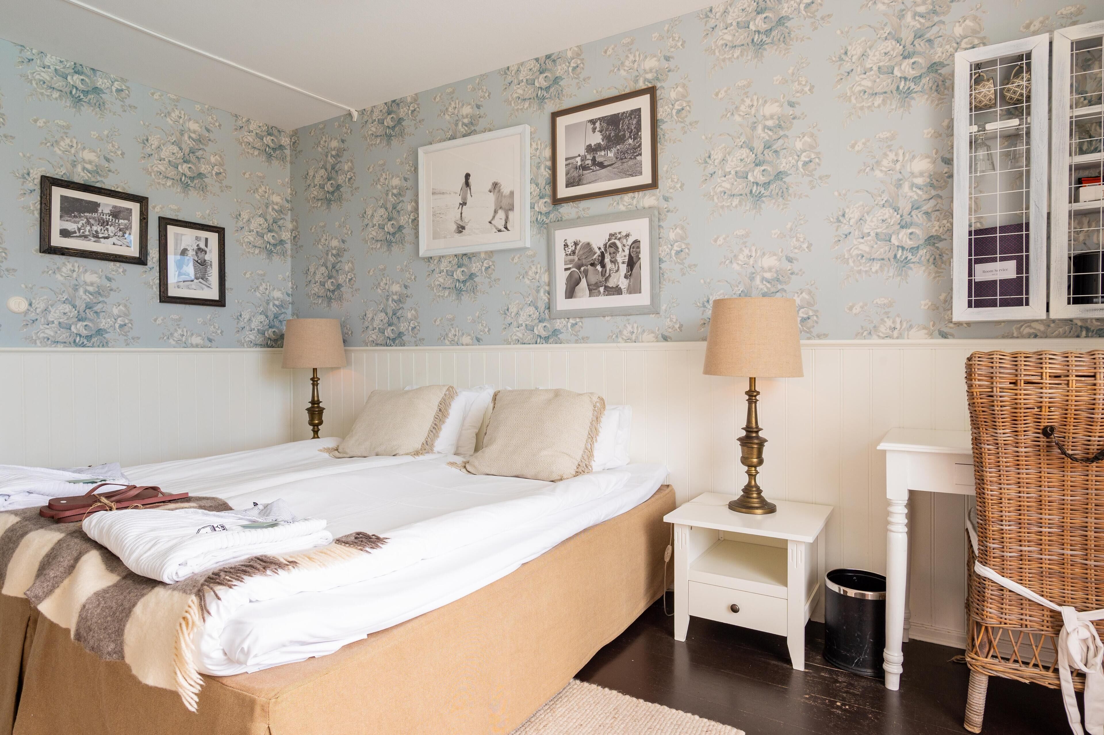 A bedroom with a bed, two bedside tables, a lamp, a chair, and a wardrobe.