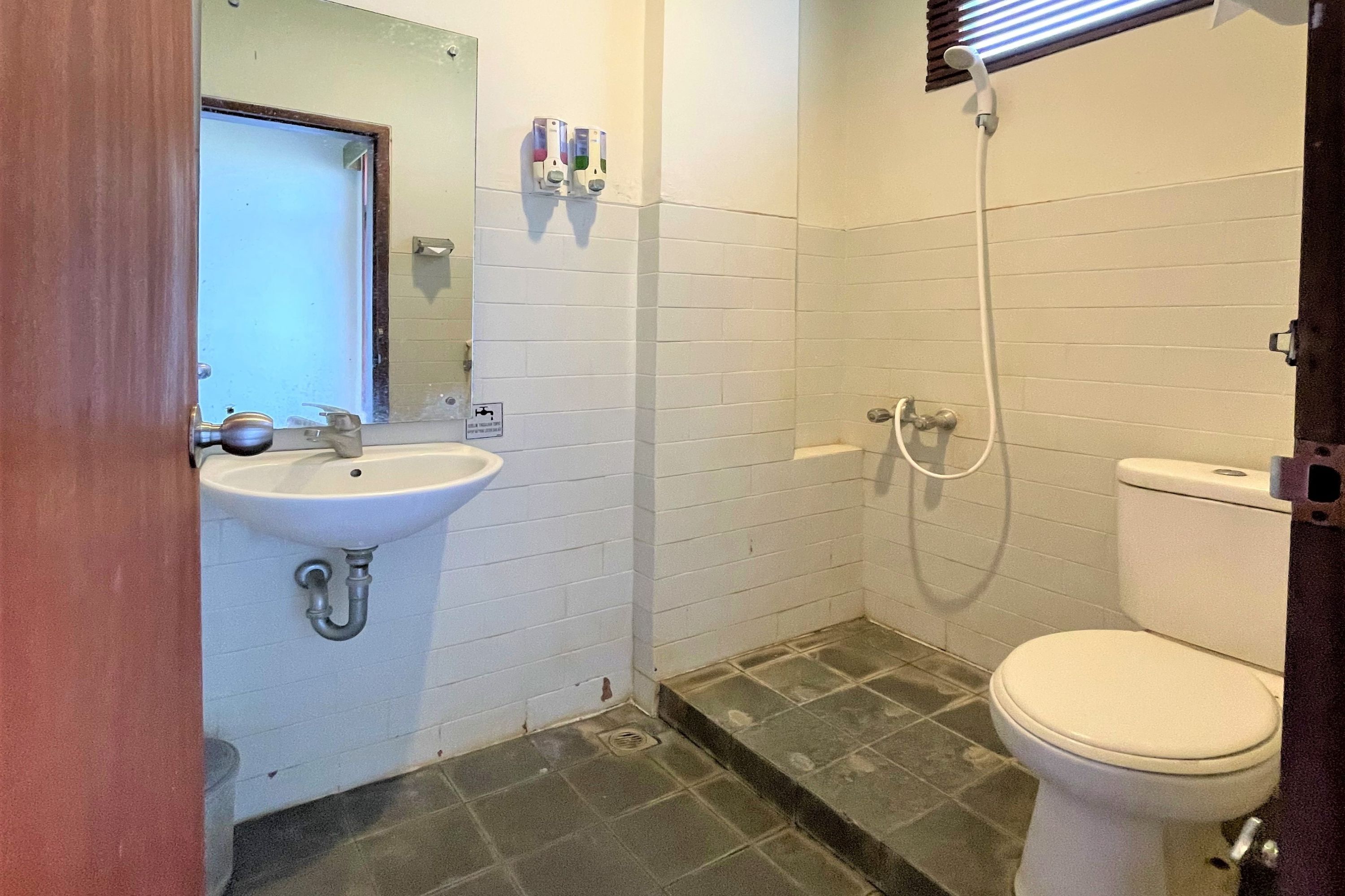 A small bathroom with a sink, toilet, and shower.