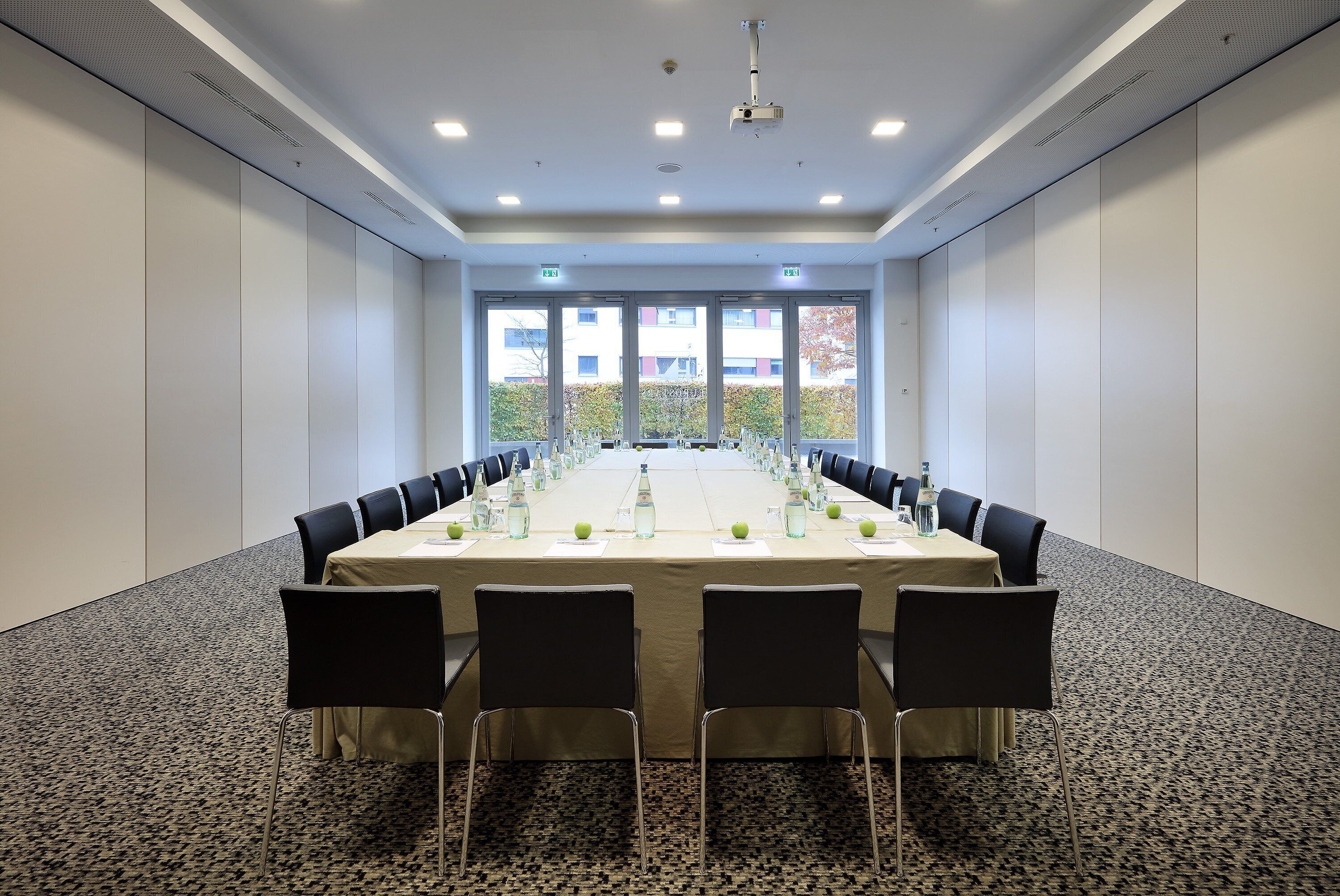 A conference room with a long table, chairs, and water bottles.