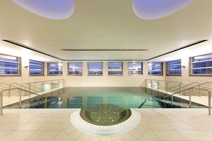 Una piscina cubierta, tumbonas