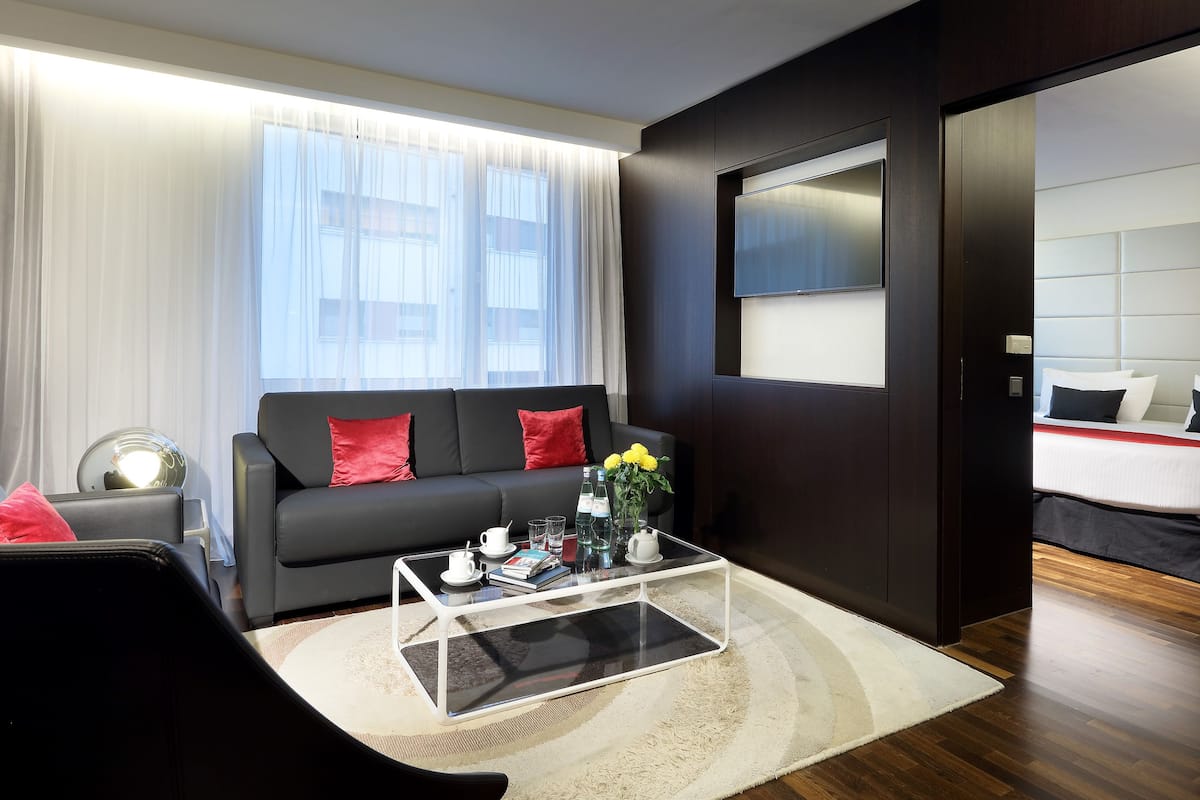A modern living room with a sofa, coffee table, and a TV mounted on the wall.