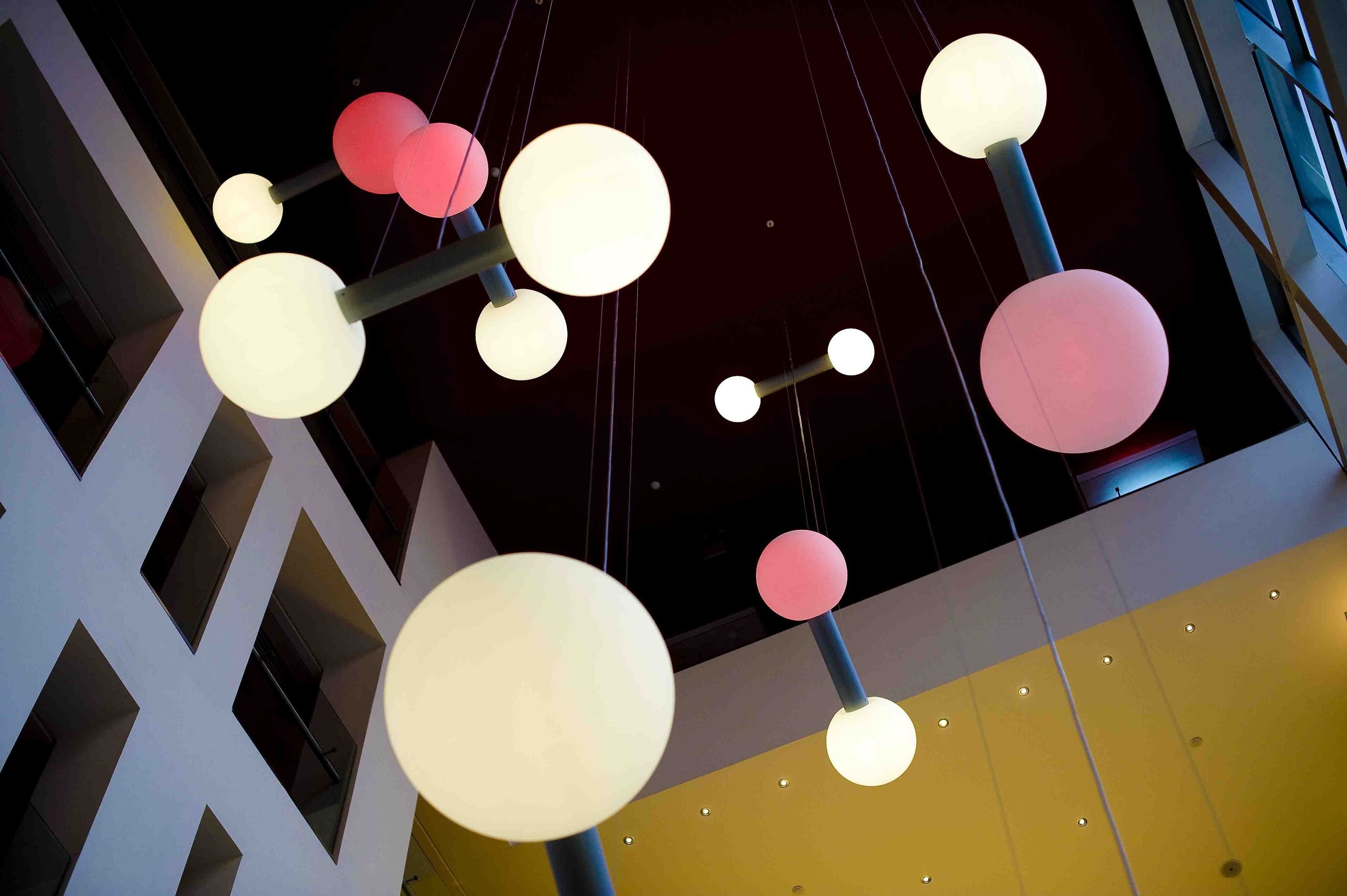 A modern interior with hanging spherical lights and geometric wall patterns.
