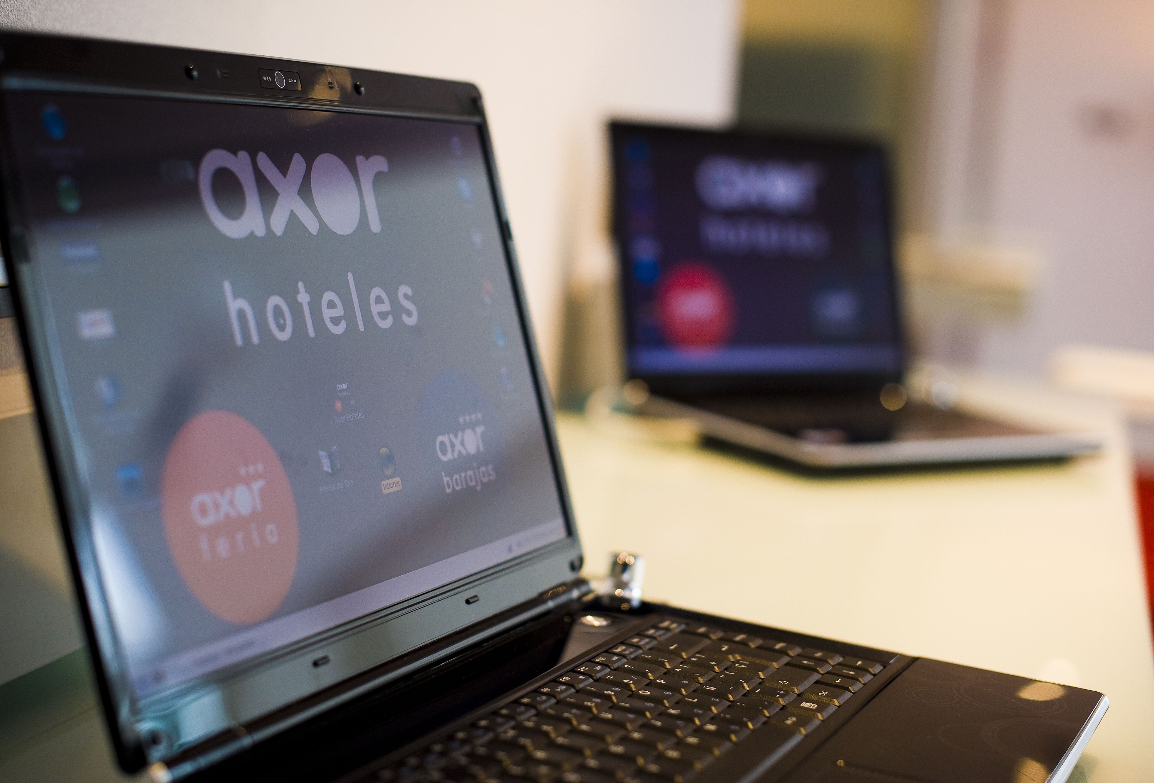 A laptop with a screen displaying 'axor hotels' and 'axor barajas'.