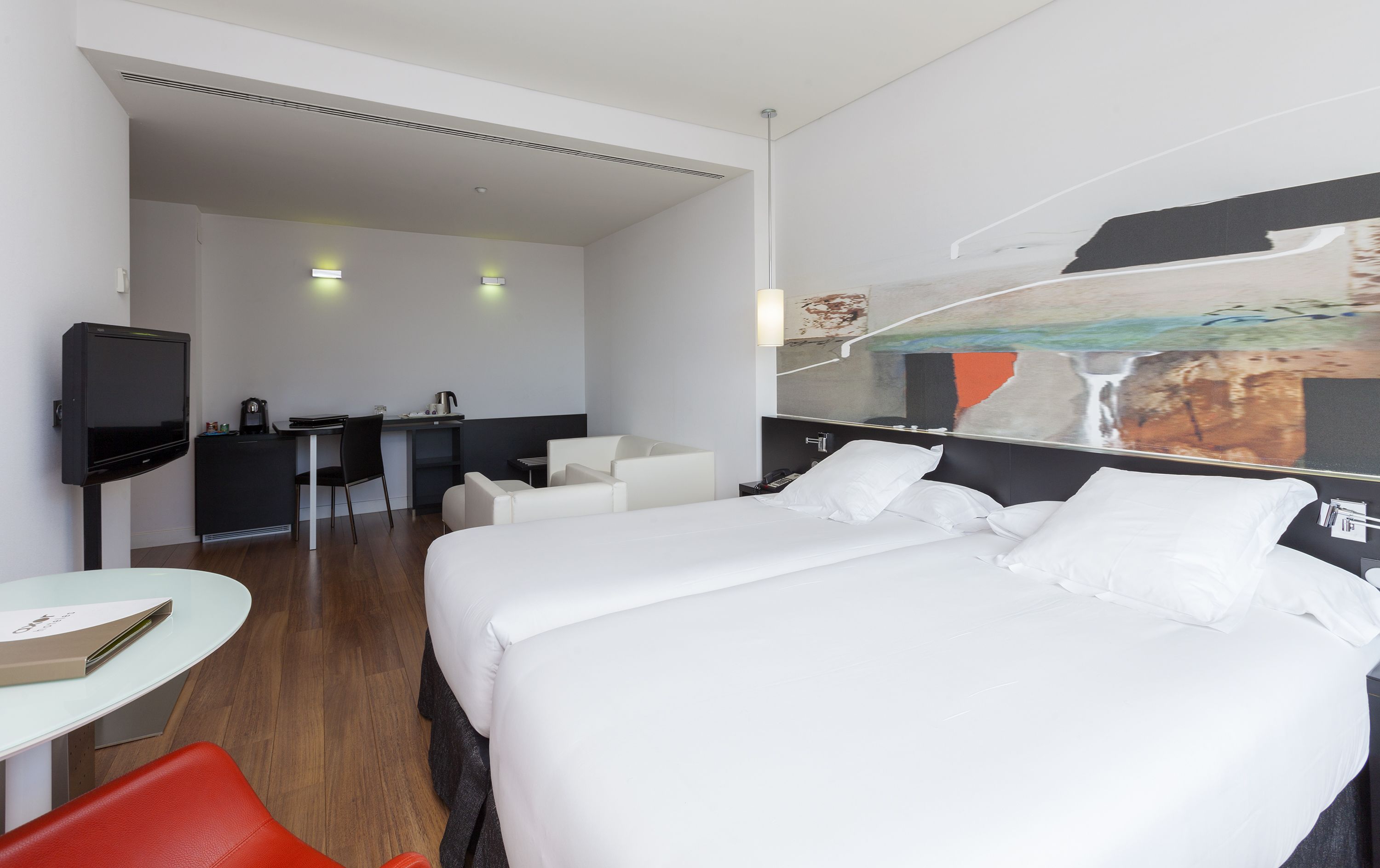 Een hotelkamer met een bed, een bureau, een stoel en een televisie.