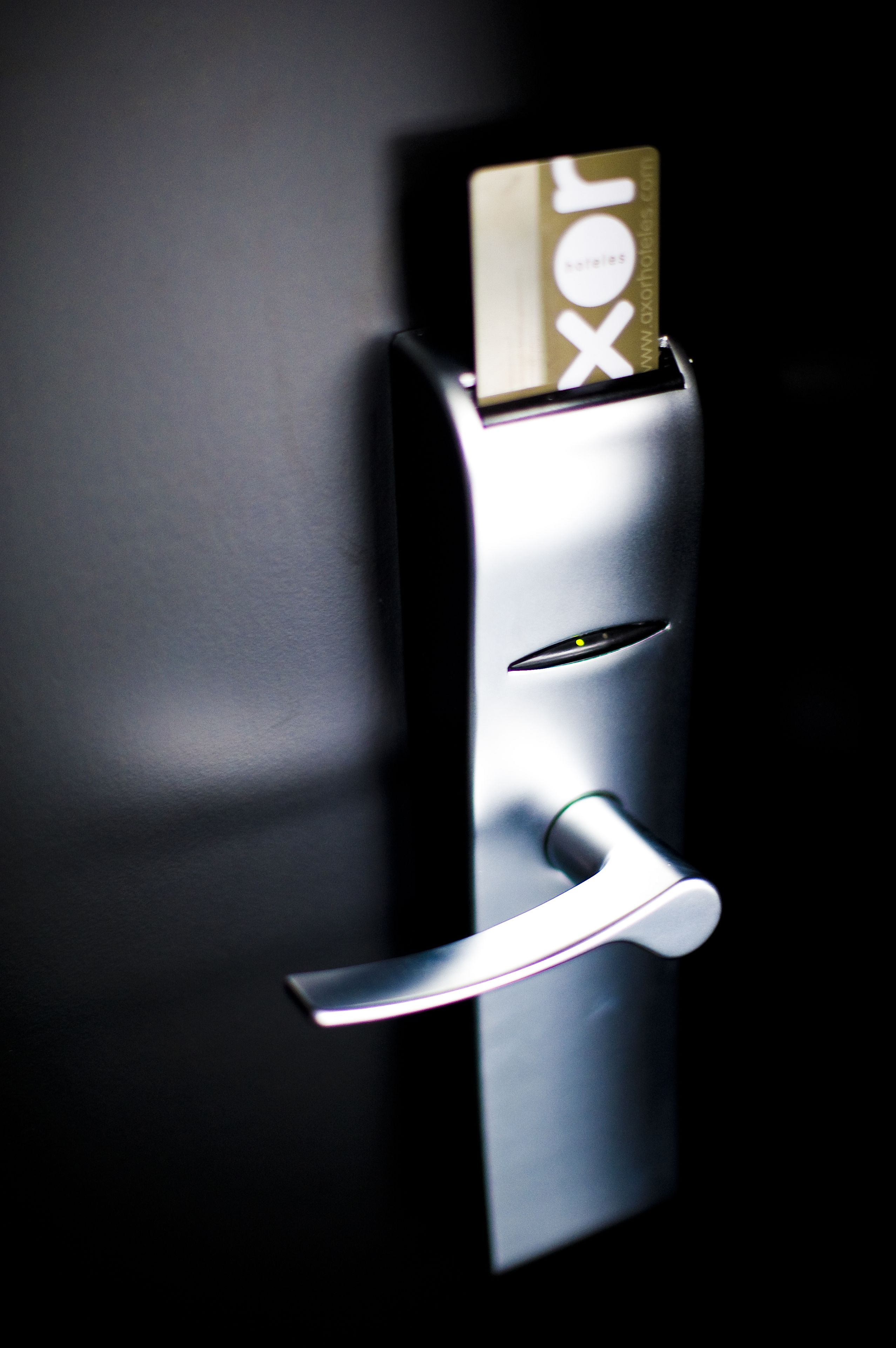 A modern door with a card reader and a keyhole.