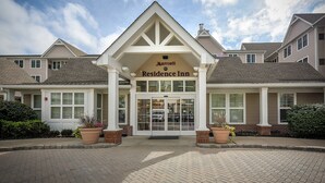 Un hôtel Marriott Residence Inn de style architectural traditionnel, avec une entrée centrale dotée de doubles portes et un ciel dégagé au-dessus.