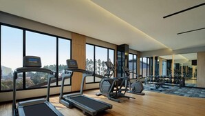 Ein modernes Fitnessstudio mit Laufbändern, Crosstrainern und Gewichten.