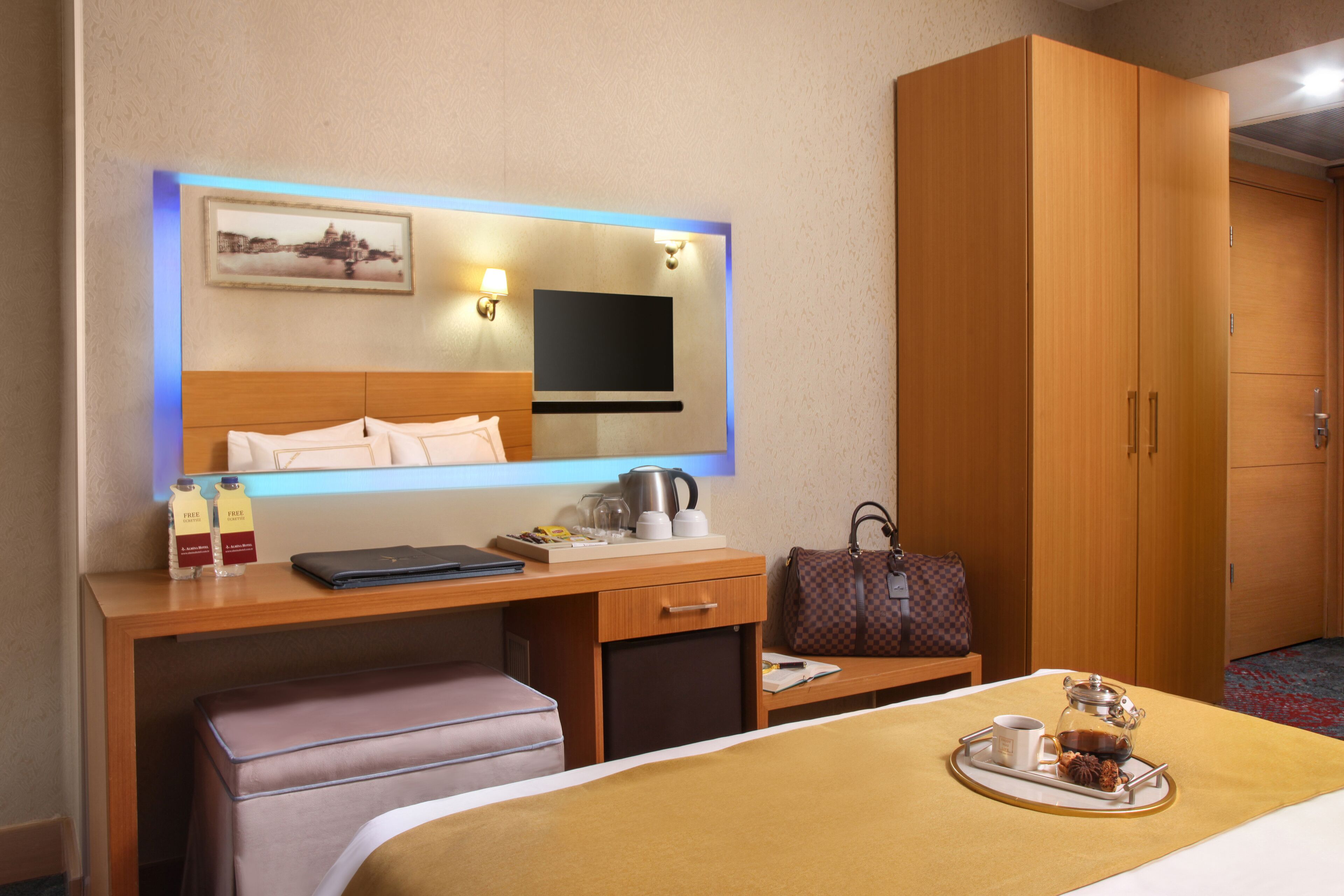 Ein Hotelzimmer mit Bett, Nachttisch, Schreibtisch und Kleiderschrank.