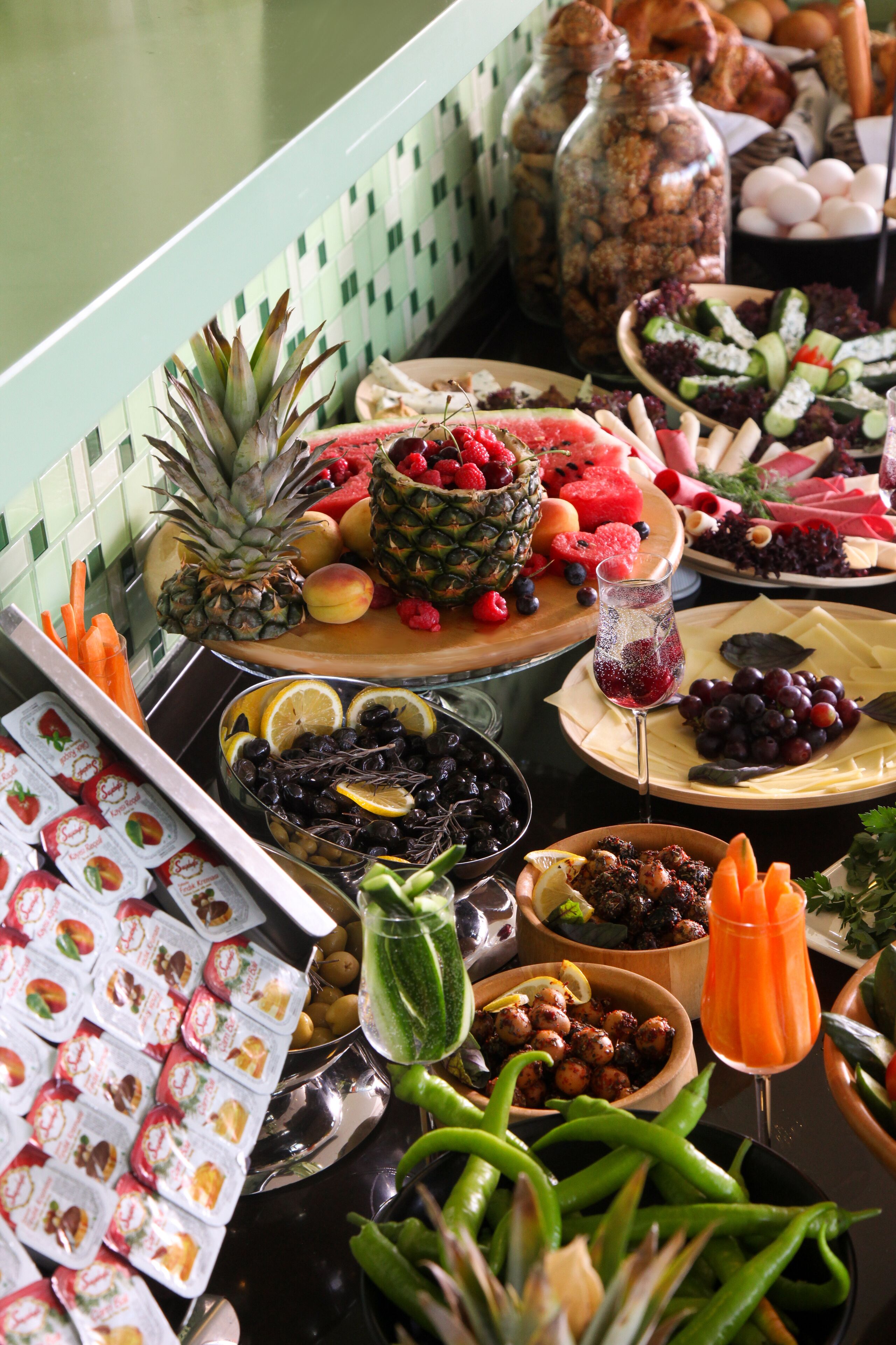 A buffet table with various food items including fruits, cheeses, and vegetables.