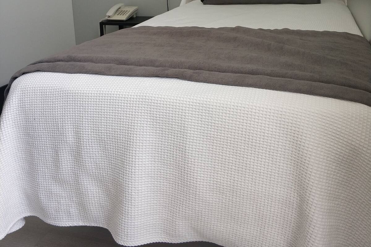 Eenvoudige eenpersoonskamer | Een kluis op de kamer, een bureau, gratis wifi, beddengoed