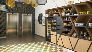 Un ascenseur, un distributeur automatique et une étagère à provisions dans un intérieur moderne.