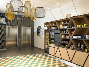 An elevator, a vending machine, and a snack shelf in a modern interior.
