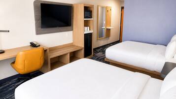 A hotel room with two beds, a desk, a chair, a TV, and a wardrobe.