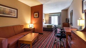 A hotel room with a sofa, a desk, a chair, a bed, and a TV. - Comfort Suites Sulphur - Lake Charles (Sulphur)