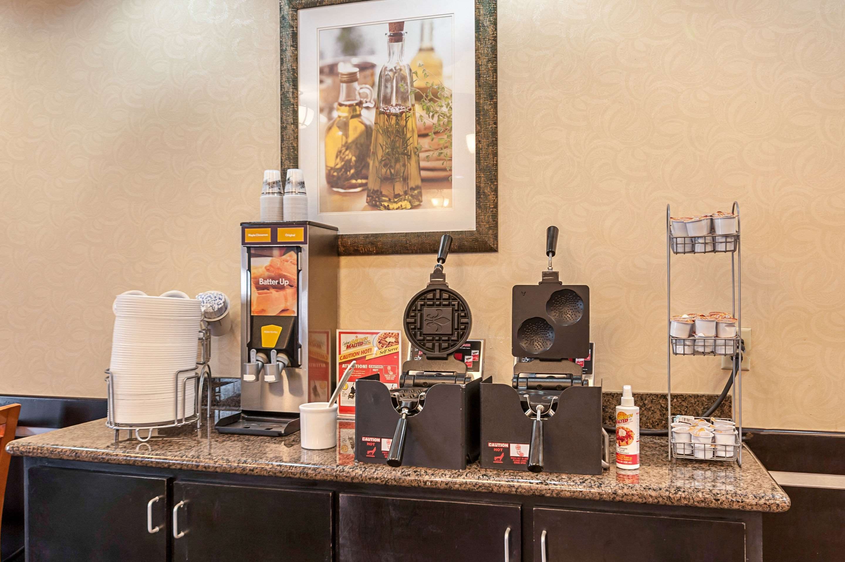 Un espace dédié au café, équipé d’un appareil à gaufres, d’une machine à café et de distributeurs de condiments.