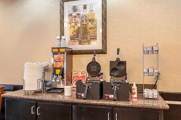 A coffee station with a waffle maker, coffee machine, and condiment dispensers. - Comfort Suites Sulphur - Lake Charles (Sulphur)