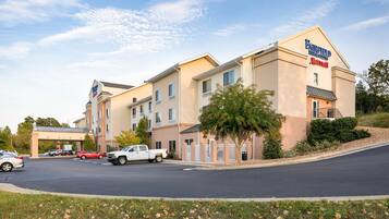 Un hotel Fairfield Inn & Suites con un estacionamiento y un cielo despejado.