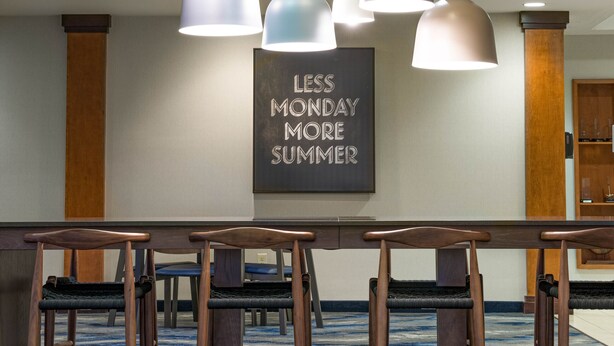 A conference room with a long table, multiple chairs, and pendant lighting. A motivational quote is displayed on the wall. - Fairfield Inn & Suites South Boston (South Boston)