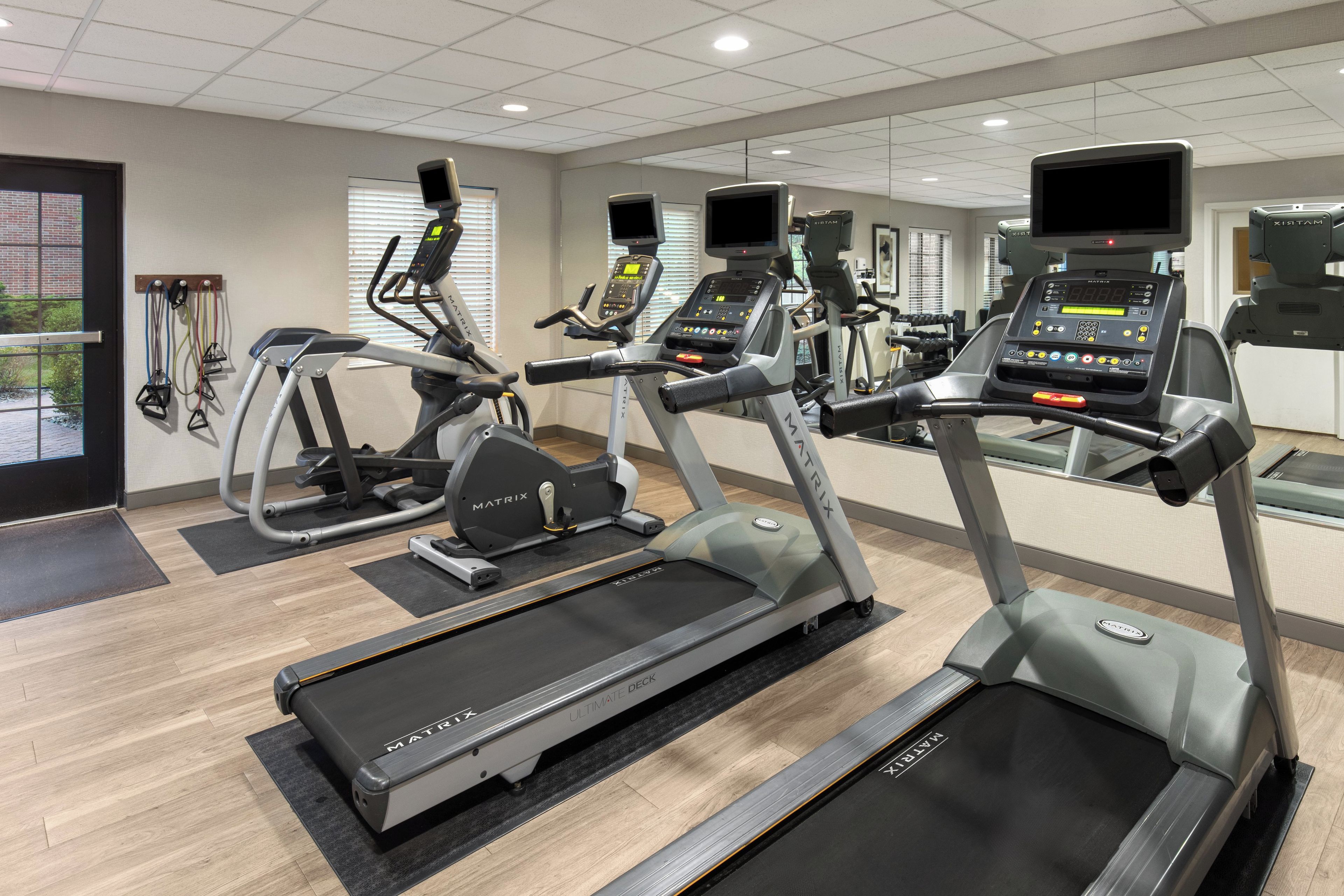 A gym with multiple treadmills, elliptical machines, and stationary bikes.