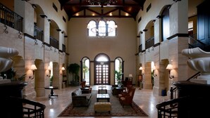 A spacious lobby with a grand chandelier, arched windows, and a central seating area with sofas and a coffee table. - Arabian Ranches Golf Club (Dubai)