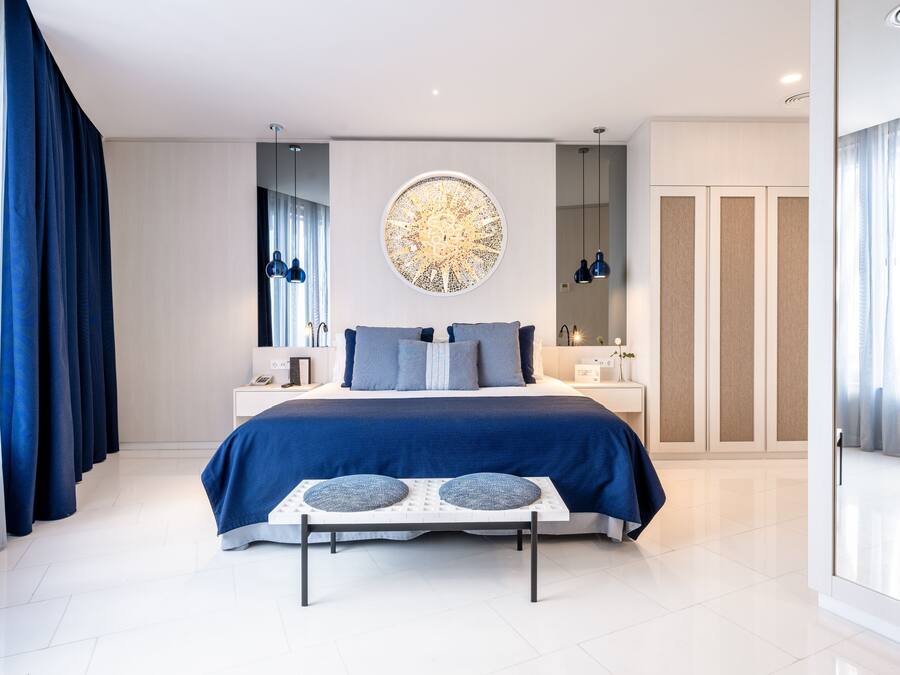Una camera da letto moderna con un letto grande, una decorazione circolare a parete e vista sulla città attraverso una grande finestra.
