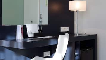A modern reception desk with a large mirror, a desk lamp, and a white chair.