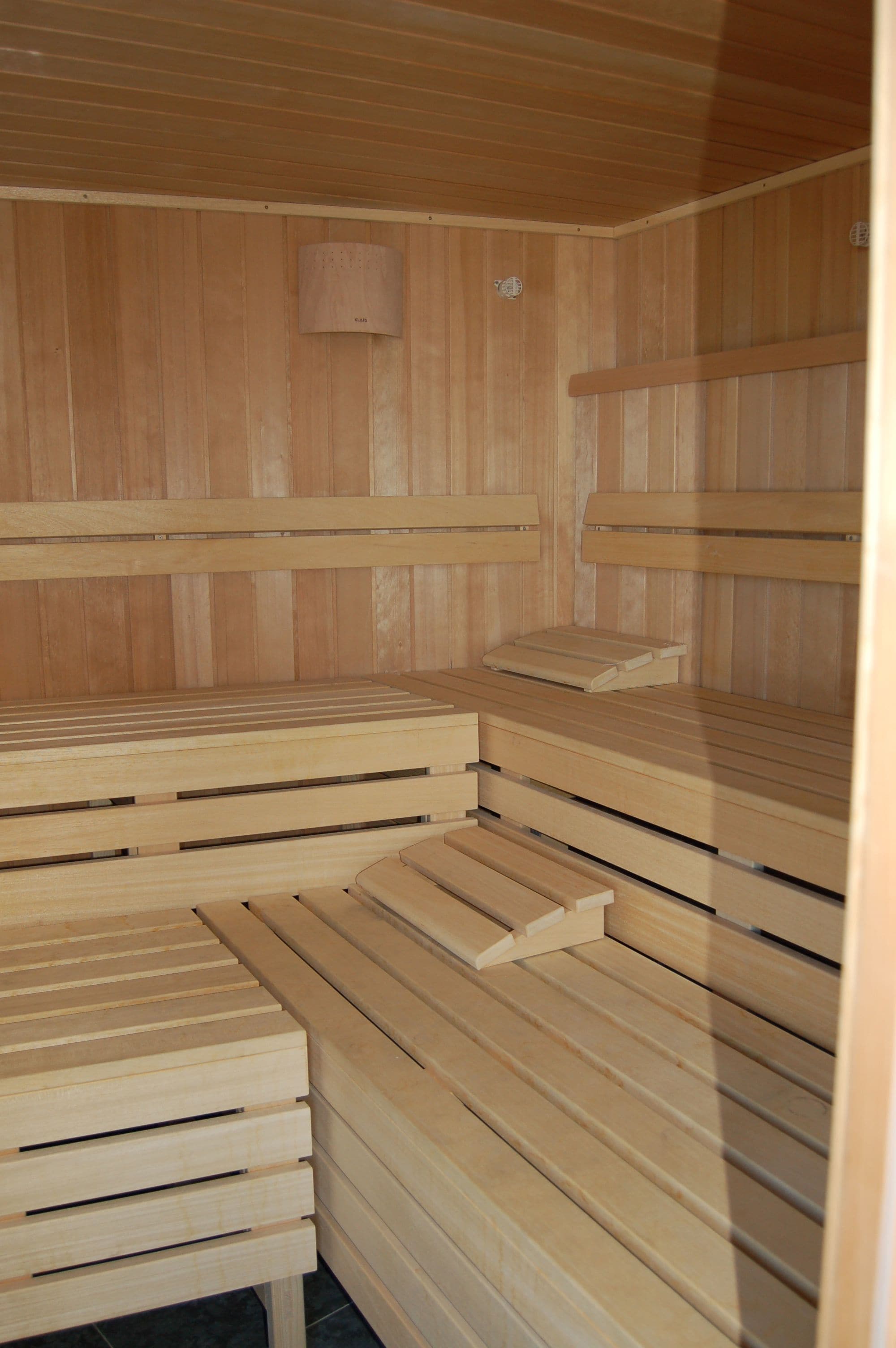 Un sauna doté de bancs en bois et d’un système de ventilation.
