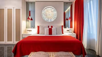 Un dormitorio moderno con una cama grande, un espejo redondo y una cortina roja.