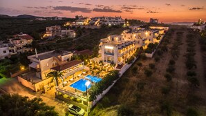 A resort with a swimming pool, multiple buildings, and a hilly backdrop. - Folia Apartments (Chania)