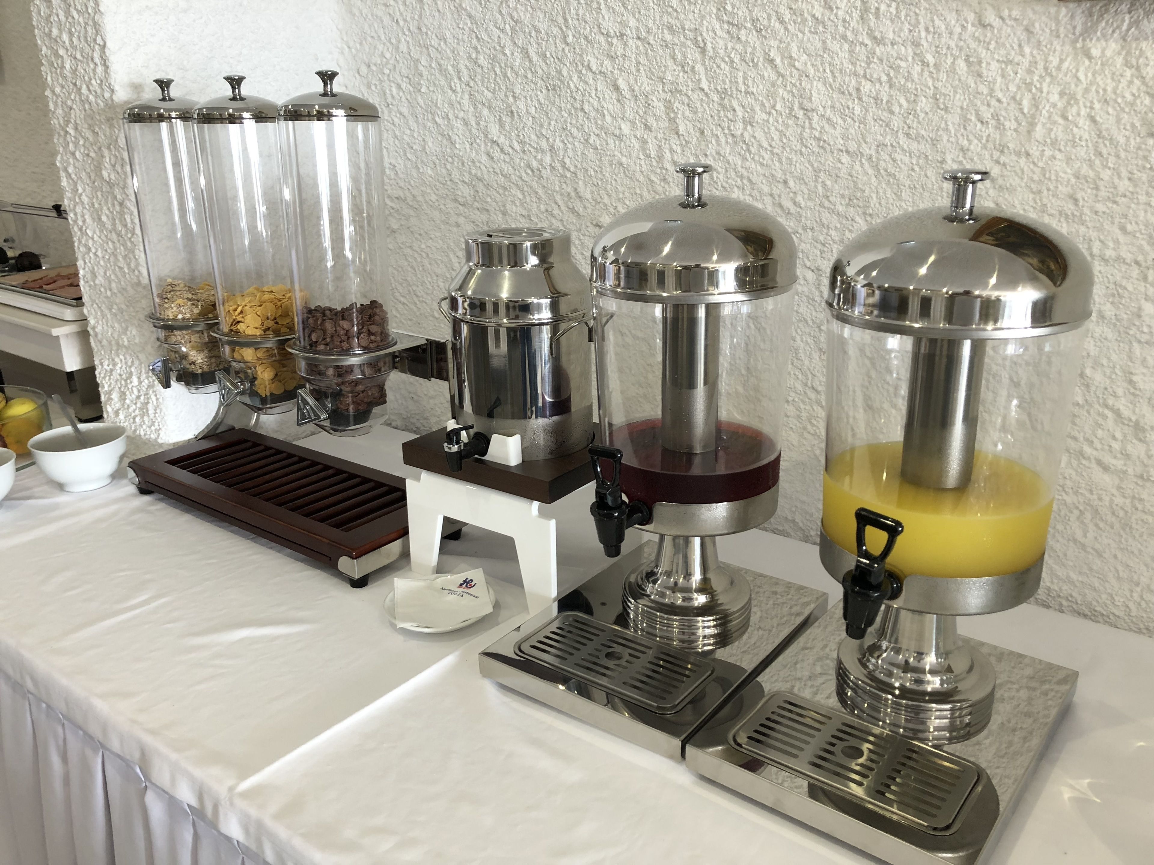 A beverage station with dispensers for coffee, tea, and juice.