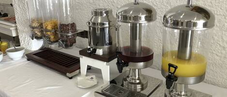A beverage station with dispensers for coffee, tea, and juice.