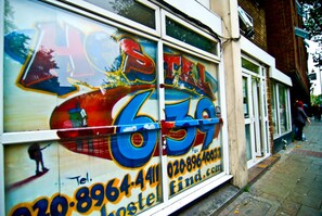 A building with large windows and a colorful advertisement. - Kensal Green Backpackers 1 (London)
