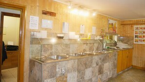 A buffet area with a marble counter and various food items displayed. - Kensal Green Backpackers 1 (London)