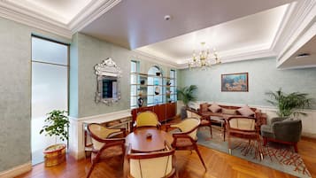 A spacious living room with a wooden coffee table, wicker chairs, a sofa, and a bookshelf.