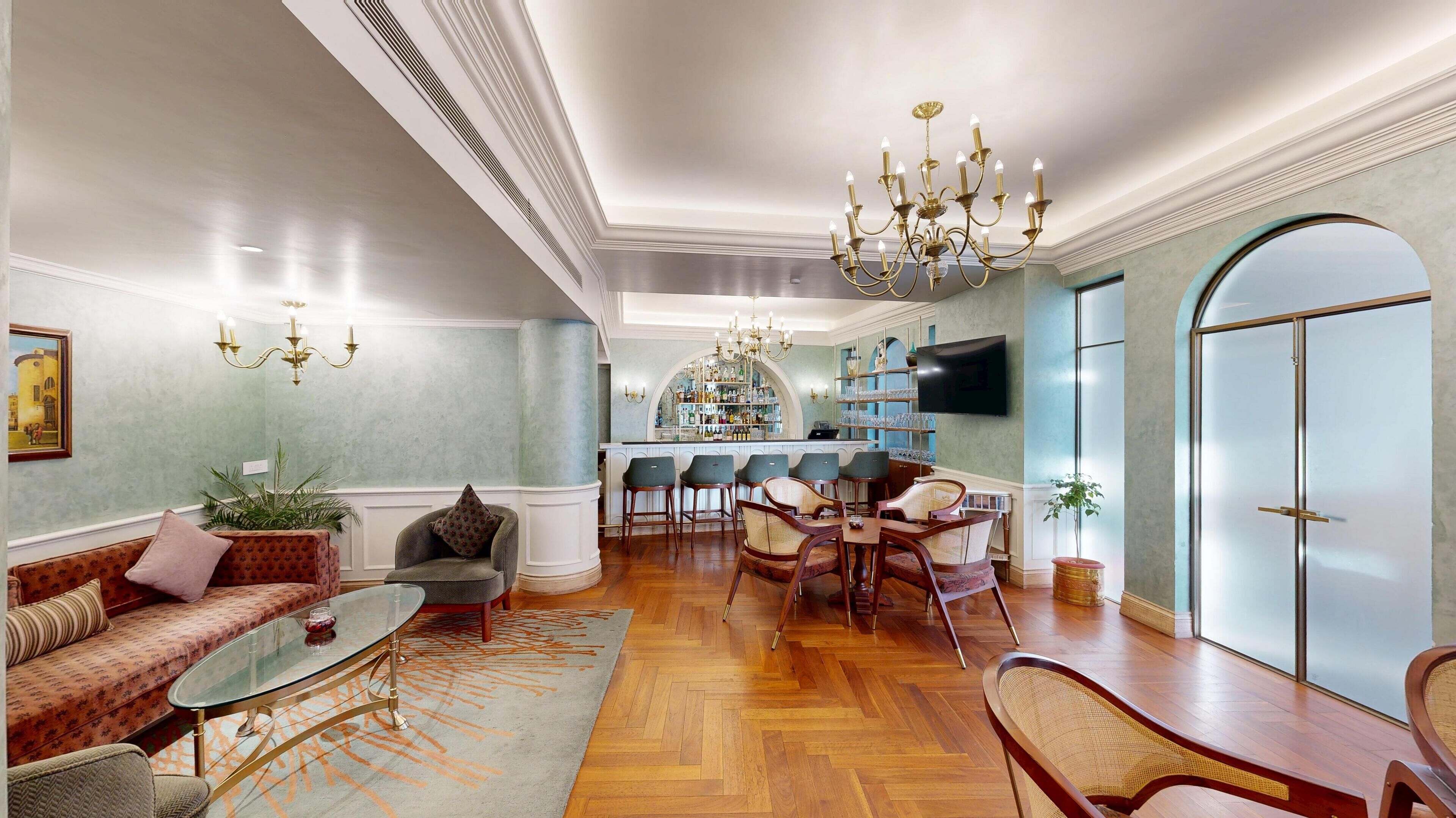 A spacious living room with a sofa, chairs, a coffee table, and a dining area with a chandelier.