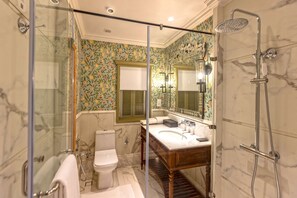 Enjoy a refreshing shower in the bathroom, featuring a glass-enclosed shower area with a showerhead and handheld shower attachment.
